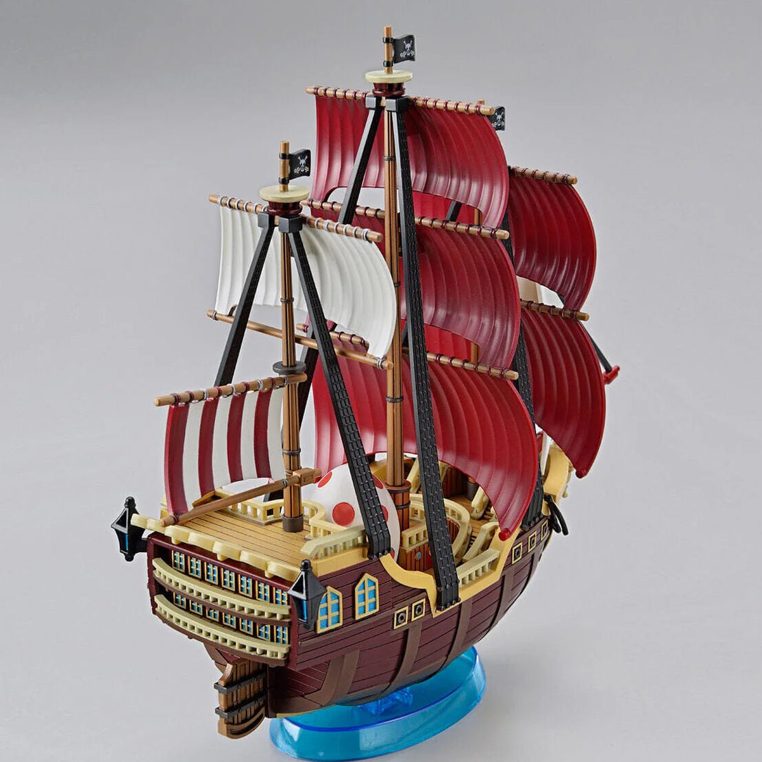 Model of a pirate ship with red sails on a gray background