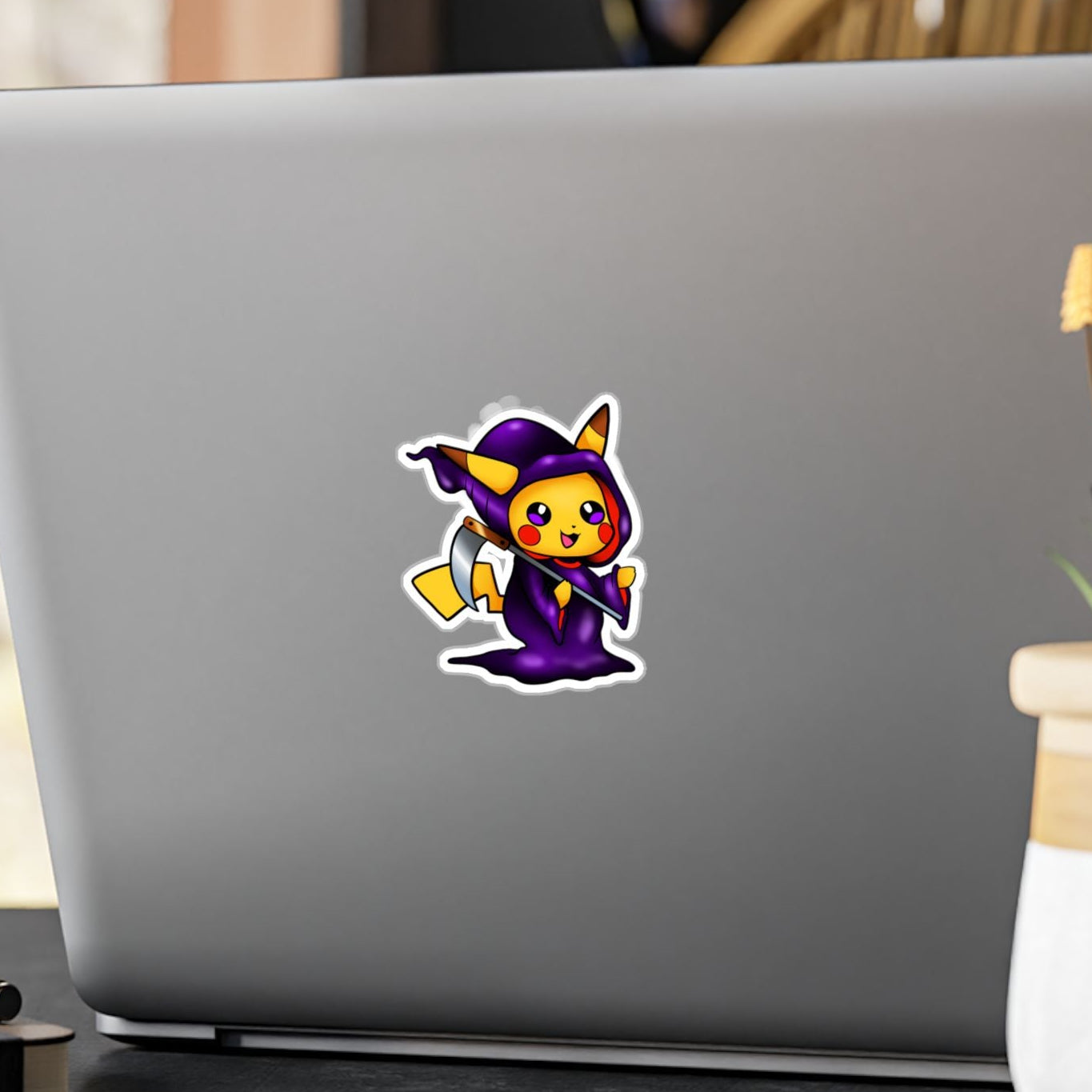 Laptop with a horse sticker on a desk with a plant and pen in the background