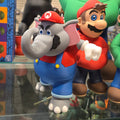 Cartoon character figurines on a reflective surface with a tiled wall background