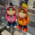 Two colorful plush toys on a reflective surface with a store interior in the background