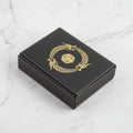 Black box with gold dragon and pentagonal symbol on a white background