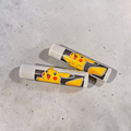 Two lip balms with Pikachu design on a gray surface