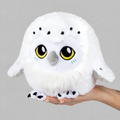 White plush owl toy held in a hand against a white background