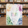 Packaging of 'Unstable Unicorns' with colorful unicorn illustrations on a white background