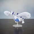 Pokémon figure of a white and blue creature on a clear stand against a white background