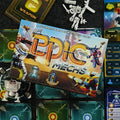 Board game packaging for 'Epic Mechs' with game pieces and cards on a dark surface.