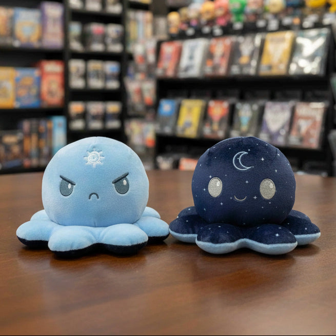 Two plush octopus toys, one blue with a sun design and one navy with a moon design, on a light gray background.
