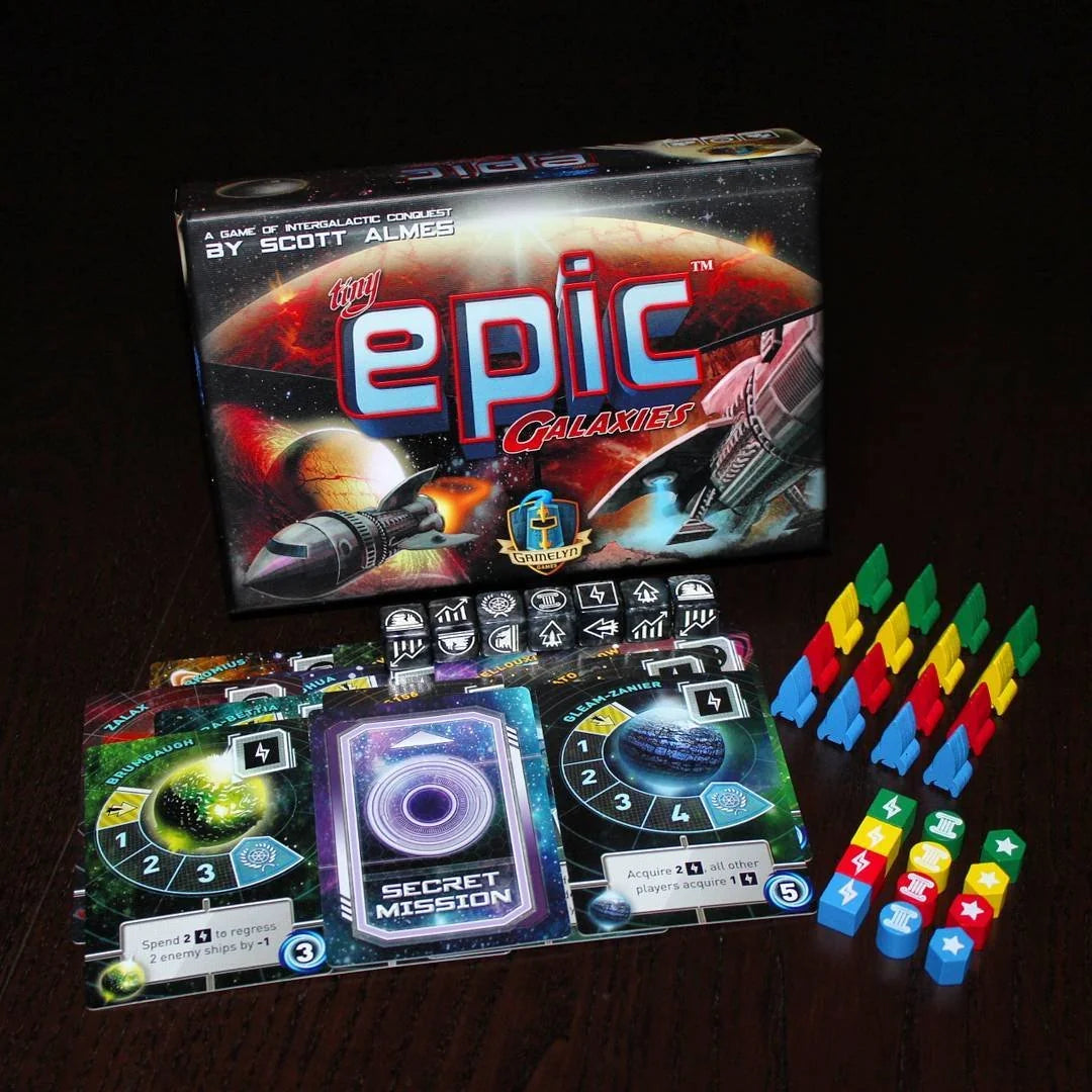 Board game set with 'Epic Galaxies' box and game pieces on a dark background