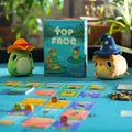 Board game 'Top Frog' with plush frog toys on a table